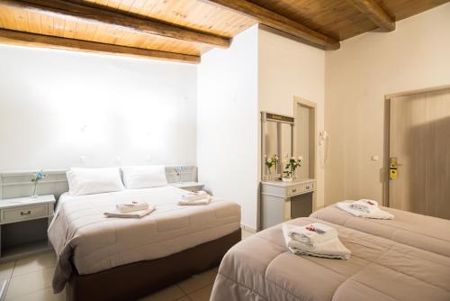 a bedroom with two beds with towels on them at Parnassos Delphi Hotel in Delfoi