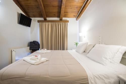 a large white bed with two towels on top of it at Parnassos Delphi Hotel in Delfoi