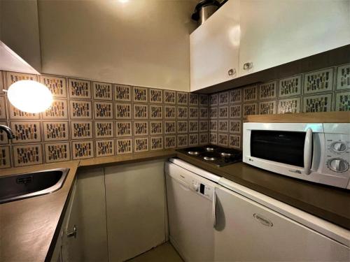 une cuisine avec un four micro-ondes sur un comptoir dans l'établissement Résidence Genepi - Studio 4 personnes avec baignoir et balcon aux Ménuires MAE-5674, aux Menuires