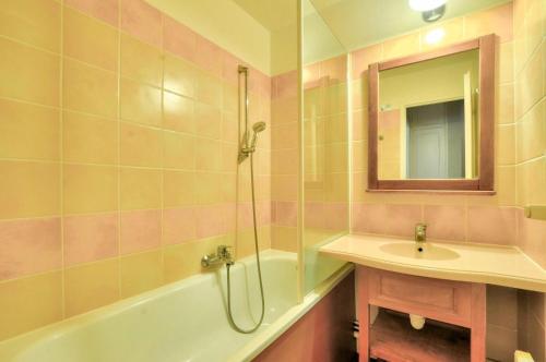 La salle de bains est pourvue d'une baignoire, d'un lavabo et d'une douche. dans l'établissement La résidence du Lac - maeva Home - Appartement 2 Pièces 4 Personnes - Sél 714, à Monflanquin