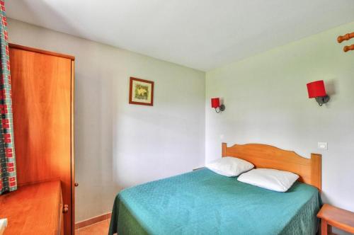 une chambre avec un lit avec un couvre-lit bleu dans l'établissement La résidence du Lac - maeva Home - Appartement 2 Pièces 5 Personnes - Sélection MAE-4294, à Monflanquin
