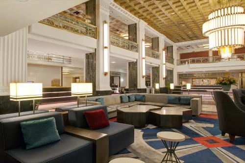 a lobby of a hotel with couches and tables at The New Yorker, A Wyndham Hotel in New York