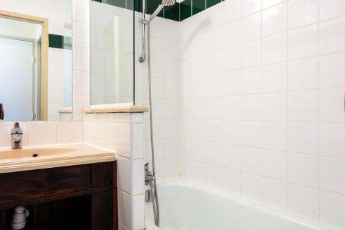 une salle de bain avec un lavabo et une douche avec un miroir dans l'établissement Résidence Les Belles Rives - maeva Home - Appartement 2 pièces 5 personnes - Confort MAE-4384, à Argentat