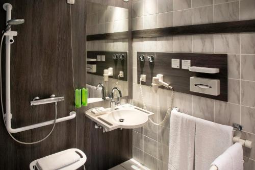 ein Bad mit einem Waschbecken und einem WC in der Unterkunft Holiday Inn Stuttgart, an IHG Hotel in Stuttgart
