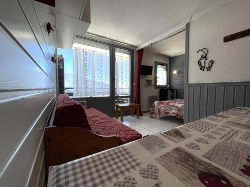 a bedroom with two beds and a large window at Résidence Villaret - Grand studio 4 personnes aux Menuires - accès 3 Vallées MAE-5734 in Les Menuires