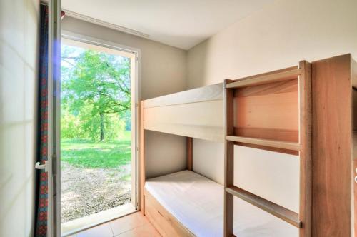Cette chambre dispose de lits superposés et d'une fenêtre. dans l'établissement La résidence du Lac - maeva Home - Maison 4 Pièces 8 Personnes - Prestige MAE-4514, à Monflanquin
