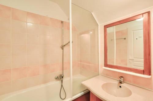 une salle de bain avec un lavabo, une baignoire et un miroir dans l'établissement La résidence du Lac - maeva Home - Maison 4 Pièces 8 Personnes - Prestige MAE-4514, à Monflanquin