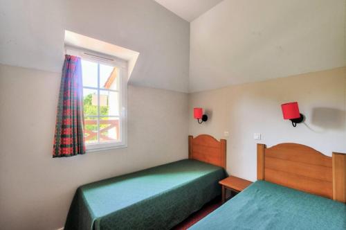 une chambre avec deux lits et une fenêtre dans l'établissement La résidence du Lac - maeva Home - Maison 3 Pièces 6 Personnes - Sélection MAE-4524, à Monflanquin