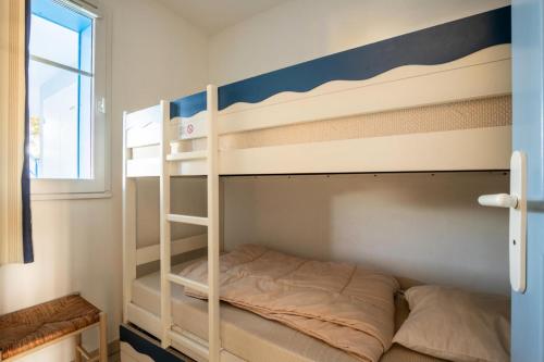Cette chambre avec lits superposés se trouve à côté d'une fenêtre. dans l'établissement Résidence Port Bourgenay - maeva Home - Appartement 2 pièces 7 personnes - Confort MAE-7054, à Talmont-Saint-Hilaire