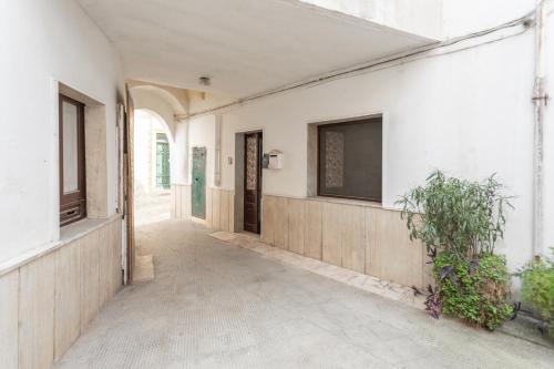 an empty hallway of a white building with a window at Appartamento Corte Delle Rondini in Taviano
