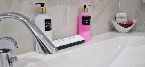 two bottles of soap sitting on a bathroom sink at Sliema Central Iprime Suites in Sliema