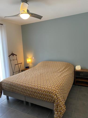 um quarto com uma cama e uma ventoinha de tecto em Maison proche des Dentelles, et du Mont-Ventoux em Aubignan