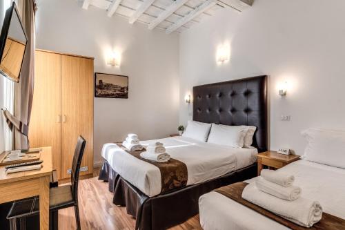 a hotel room with two beds and a desk at Magenta Deluxe Cancello in Rome