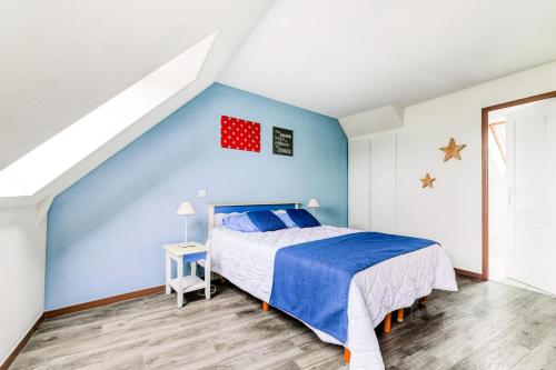une chambre avec un lit et un mur bleu dans l'établissement Résidence Port du Crouesty - maeva Home - Appartement 2 pièces 5 personnes - Sélection - vue sur le Port MAE-7114, à Arzon