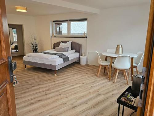 a bedroom with a bed and a table with chairs at Die Alte Apotheke _ Apartment Nr.2 in Baiersbronn