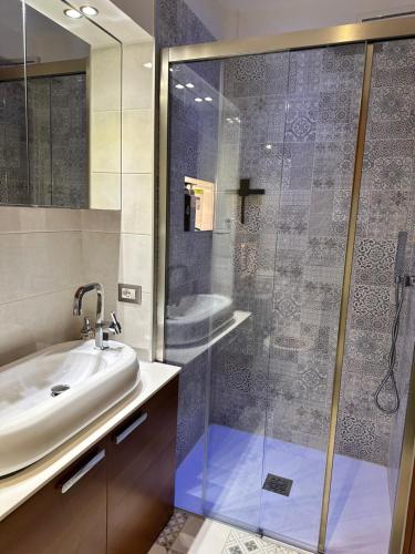 a bathroom with a glass shower and a sink at Sergiunca in Bocca di Magra