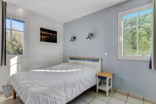 ein weißes Schlafzimmer mit einem Bett und zwei Fenstern in der Unterkunft Résidence Port Bourgenay - maeva Home - Appartement 3 Pièces 7 Personnes - 584 in Talmont