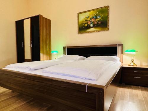 ein großes Bett in einem Schlafzimmer mit zwei Lampen in der Unterkunft Pension Liechtenstein in Wien