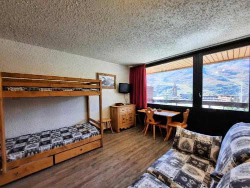 - une chambre avec 2 lits superposés, une table et un bureau dans l'établissement Résidence Aravis - Studio pour 3 personnes avec blacon exposé Sud MAE-5944, aux Menuires