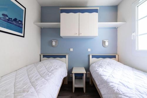 deux lits dans une chambre aux murs bleus dans l'établissement Port du Crouesty Cap'Océan - maeva Home - Appartement 2 Pièces 4 Personnes - Sélection MAE-0784, à Arzon