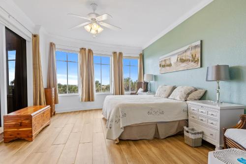een slaapkamer met een groot bed en een plafondventilator bij Oceanfront Luxury: Andros in Minorca Great Amenities Breathtaking Views in New Smyrna Beach