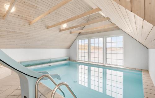 einen Pool in einem Zimmer mit einem großen Fenster in der Unterkunft 4 Bedroom Amazing Home In Ringkøbing in Nørre Lyngvig