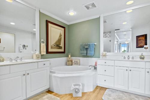 een witte badkamer met een bad en 2 wastafels bij Oceanfront Luxury: Andros in Minorca Great Amenities Breathtaking Views in New Smyrna Beach