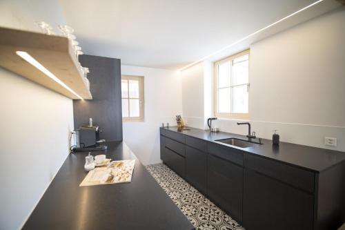 a kitchen with a black counter and a sink at Chasa Muntanella in Ftan