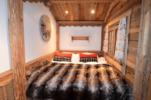 a large bed in a room with wooden walls at Résidence Necou - Studio pour 3 Personnes 954 in Les Menuires