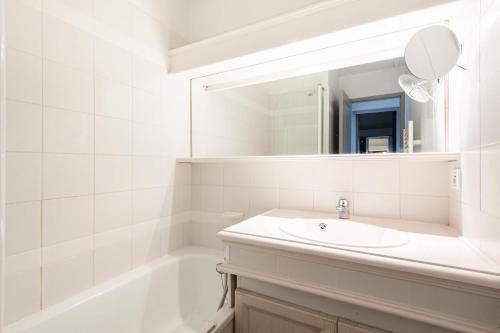 uma casa de banho branca com um lavatório e um espelho em Village Pont Royal en Provence - maeva Home - Appartement 2 Pièces 6 Person 814 em Mallemort