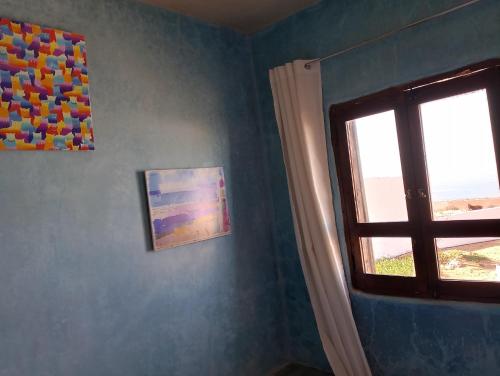a room with a window and paintings on the wall at Riad & Restaurant Ocean Beach Douira in Agadir