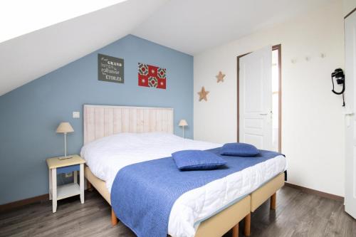 - une chambre avec un grand lit et un mur bleu dans l'établissement Port du Crouesty Cap'Océan - maeva Home - Appartement 2 pièces 7 personnes 834, à Arzon