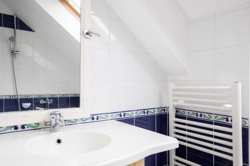 une salle de bain avec un lavabo et un miroir dans l'établissement Port du Crouesty Cap'Océan - maeva Home - Appartement 3 pièces 7 personnes - Sélection - vue sur le Port MAE-0834, à Arzon