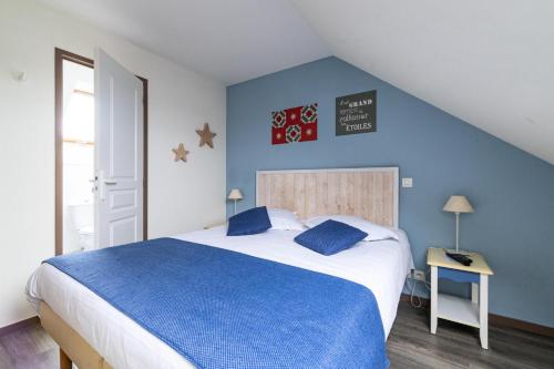 une chambre avec un grand lit aux murs bleus dans l'établissement Port du Crouesty Cap'Océan - maeva Home - Appartement 3 pièces 7 personnes - Sélection - vue sur le Port MAE-0824, à Arzon
