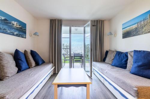 un salon avec un canapé et une table dans l'établissement Port du Crouesty Cap'Océan - maeva Home - Appartement 2 pièces 5 personnes - Sélection - vue sur le Port MAE-0844, à Arzon