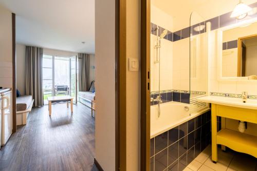 La salle de bains est pourvue d'un lavabo et d'une baignoire. dans l'établissement Port du Crouesty Cap'Océan - maeva Home - Appartement 2 pièces 5 personnes - Sélection - vue sur le Port MAE-0844, à Arzon