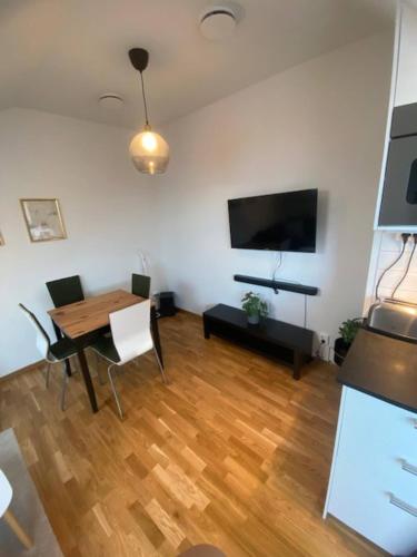 a living room with a dining room table and a flat screen tv at Cozy Apartment Close To Central Station in Gothenburg
