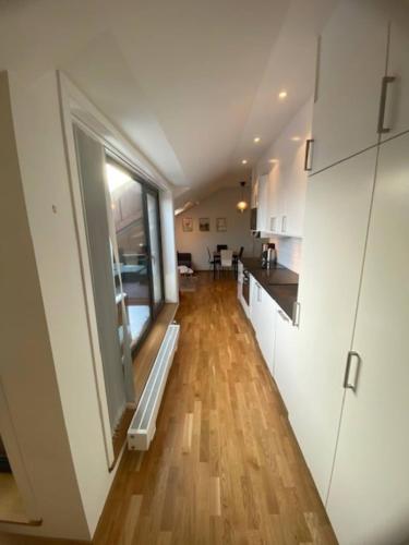 a kitchen with a large window and a wooden floor at Cozy Apartment Close To Central Station in Gothenburg