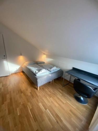 a small bedroom with a bed and a desk at Cozy Apartment Close To Central Station in Gothenburg