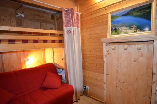 - un salon avec un canapé rouge et une fenêtre dans l'établissement Résidence Genepi - Beau studio déco espri chalet aux Ménuires MAE-6014, aux Menuires