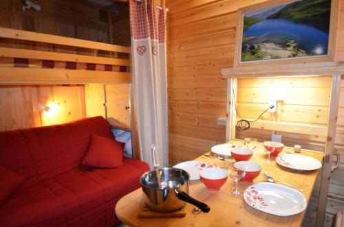 Cette chambre comprend une table avec des verres à vin et un canapé. dans l'établissement Résidence Genepi - Beau studio déco espri chalet aux Ménuires MAE-6014, aux Menuires