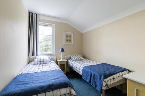 deux lits dans une chambre avec une fenêtre dans l'établissement Résidence Port Bourgenay - maeva Home - Appartement 3 pièces 6 personnes - Prestige MAE-0884, à Talmont-Saint-Hilaire