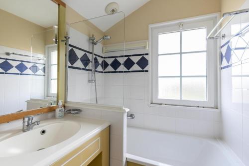 La salle de bains est pourvue d'un lavabo, d'une baignoire et d'une fenêtre. dans l'établissement Résidence Port Bourgenay - maeva Home - Appartement 3 pièces 6 personnes - Prestige MAE-0884, à Talmont-Saint-Hilaire