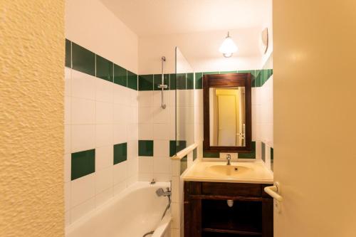une salle de bain avec un lavabo, une baignoire et un miroir dans l'établissement Le Domaine du Golf de Pinsolle - maeva Home - Appartement 2 pièces 5 personnes - Confort MAE-7244, à Soustons