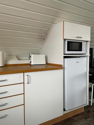 a kitchen with a microwave and a refrigerator at Overnatning tæt på Silkeborg in Engesvang
