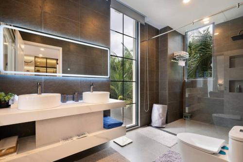 uma casa de banho com 2 lavatórios e um chuveiro em Wonderland Villa at Ho Tram Beach em Ho Tram