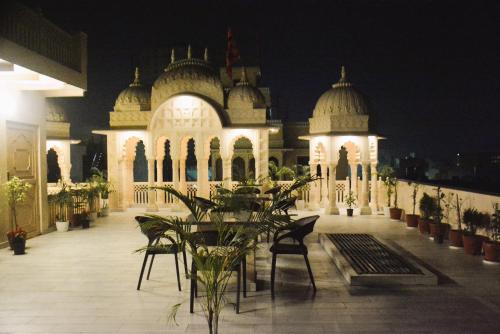 un edificio iluminado con sillas y plantas delante de él en Gupta Vilas - A Boutique Homestay, en Agra
