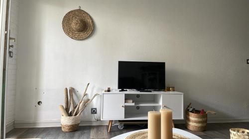 a living room with a tv on a white cabinet at Studio Bayonne avec Piscine in Bayonne