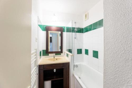 une salle de bain avec un lavabo, un miroir et une baignoire dans l'établissement Le Domaine du Golf de Pinsolle - maeva Home - Appartement 2 pièces 6 personnes - Confort MAE-2684, à Soustons