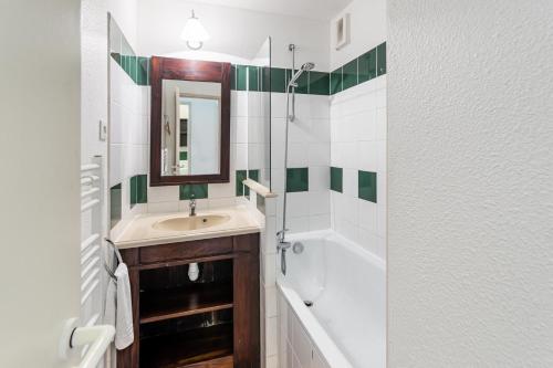 une salle de bain avec un lavabo et un miroir dans l'établissement Le Domaine du Golf de Pinsolle - maeva Home - Appartement 2 pièces 6 personnes - Sélection MAE-2694, à Soustons